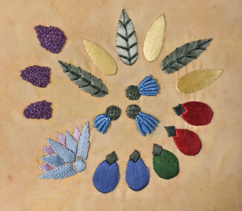 Faience Necklace Photograph of an embroidery depicting faience beads from a necklace. The embroidery uses glossy flat silk thread, and the stitches are chosen to help bring to mind not just the beads, but the fruits and flowers that inspired them.